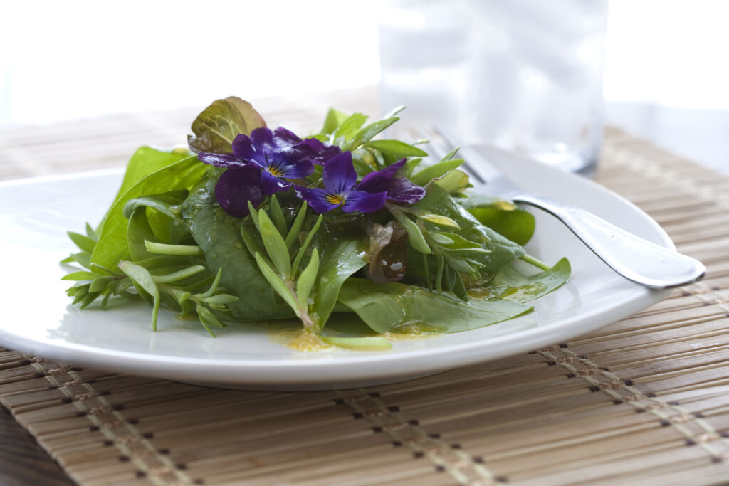 Photo d'une salade verte garnie de fleurs comestibles