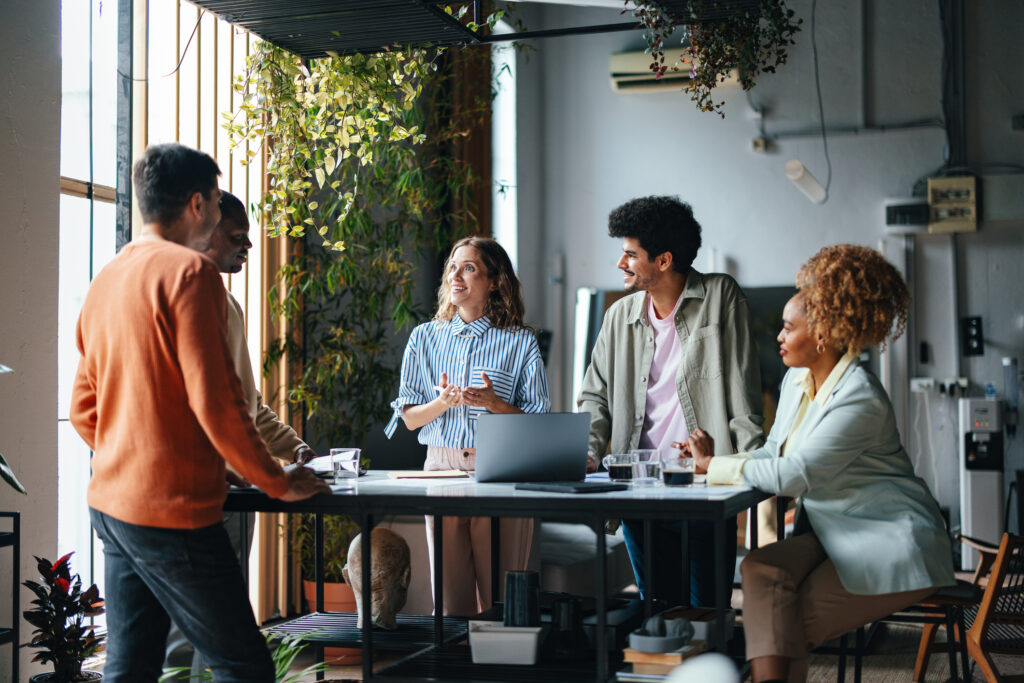 Une discussion d’un groupe de personnes diverses qui travaillent sur le même projet debout autour d’une table.
