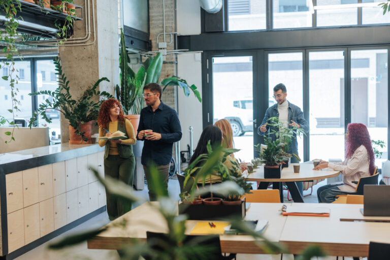 L'&eacute;quipe de la marque Cultive travaillant dans un espace de travail v&eacute;g&eacute;talis&eacute;, illustrant la culture responsable et collaborative de Cultive.